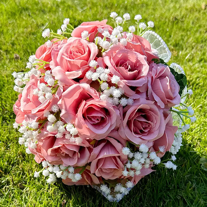 A delicate white silk rose wedding bouquet with lace pearls featuring soft pink artificial roses and tiny white filler flowers.