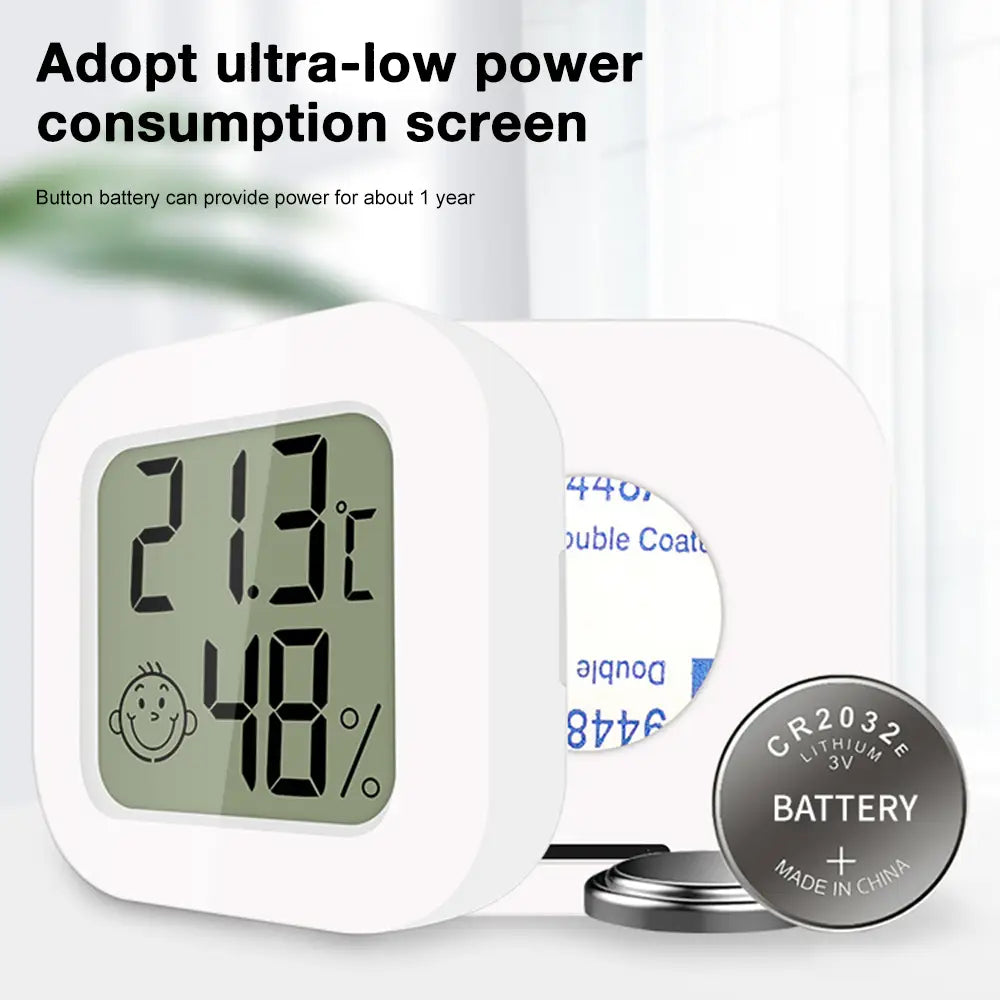 White square digital thermometer and hygrometer room sensor with a green screen displaying 21.3°C and 48 percent humidity powered by a CR2032 lithium battery featuring an accurate measurement range.