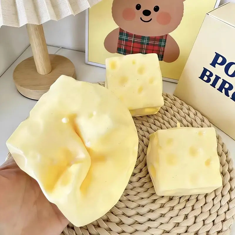 juguetes blandos de descompresión de crecimiento lento con forma de queso amarillos con orificios moldeados y una textura blanda y flexible para aliviar el estrés, visibles desde el ángulo frontal