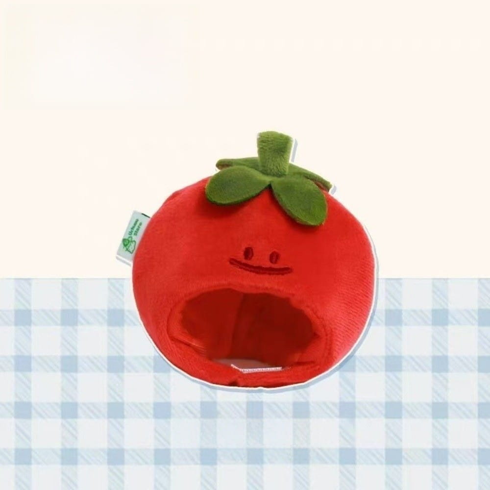 Red plush tomato-shaped pet bed with green leafy top and embroidered smile face designed as a 10cm plush doll headgear animal costume.