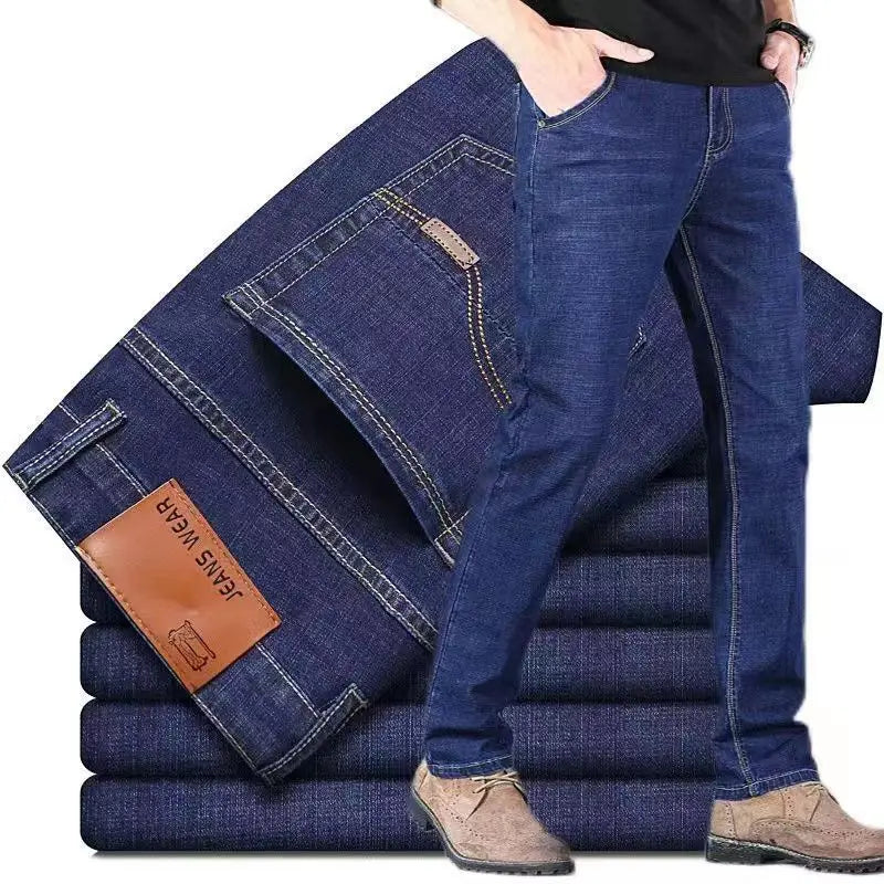 Vue arrière des jeans stretch en denim bleu foncé à jambe droite pour homme, avec un écusson de marque en cuir brun indiquant « jeans wear » sur la poche arrière
