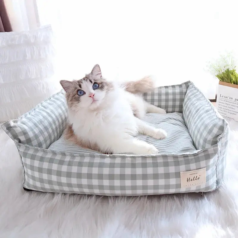A cozy gray and white checkered plush gingham check pet bed made of cotton with soft cushioned edges designed as a dog sofa.