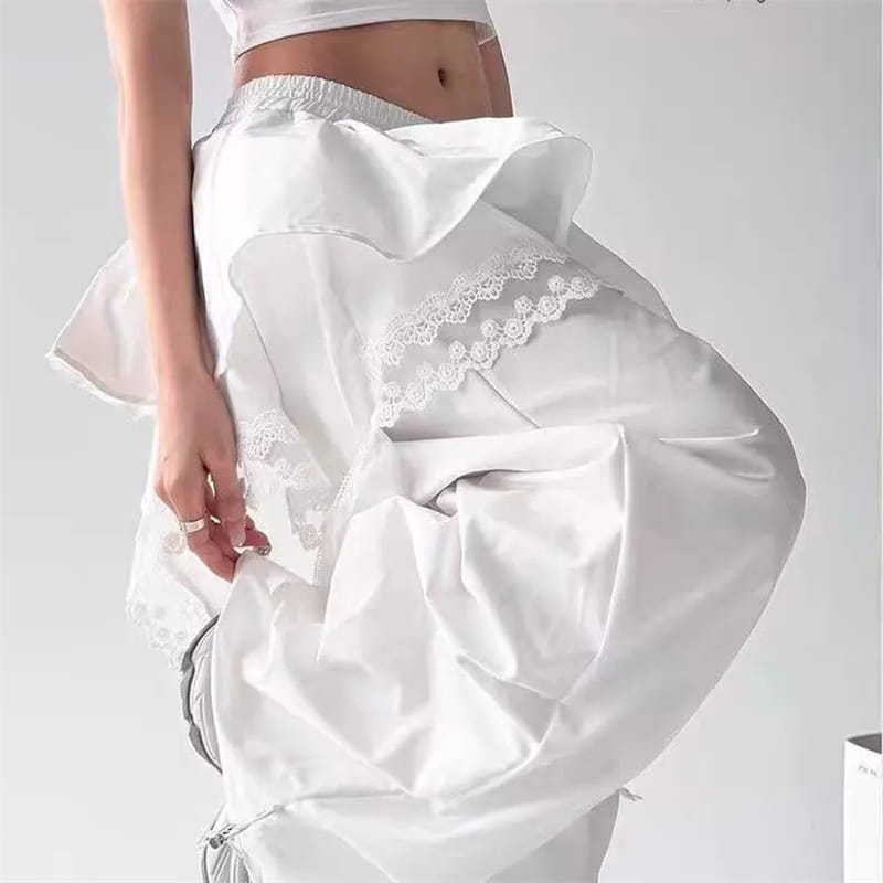 繊細なレーストリムを施したホワイトサテンのワイドレッグパンツ。流れるようなボリュームのあるシルエット。