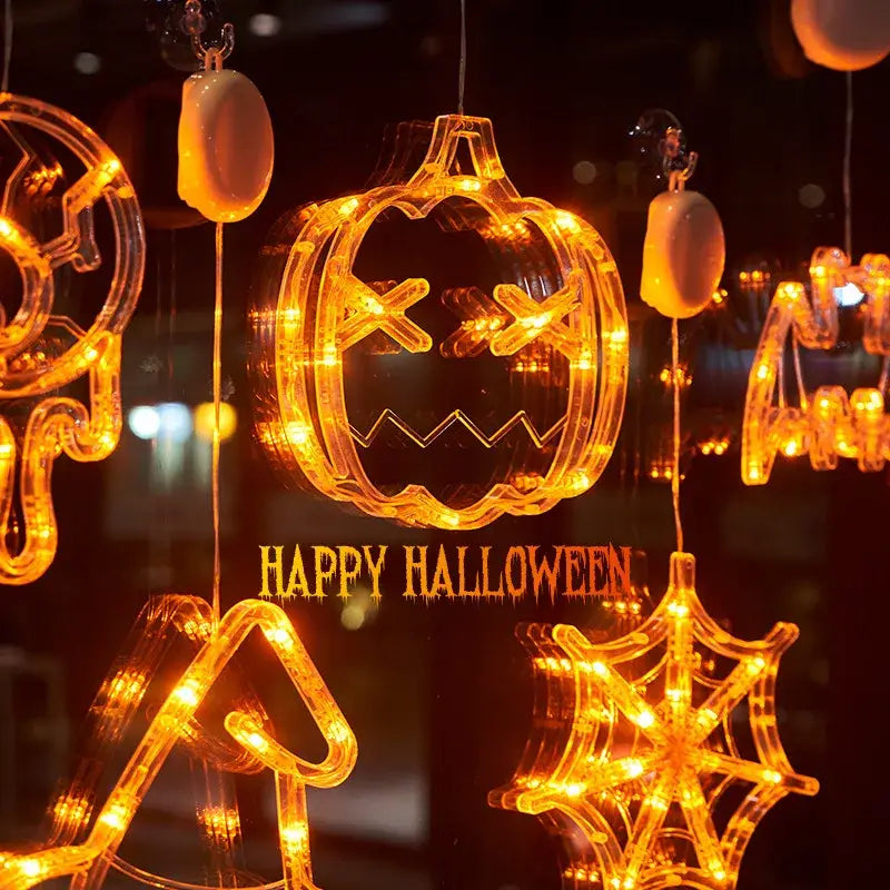 halloween window light battery operated pumpkin ghost decor featuring an orange led-lit pumpkin-shaped decoration made of translucent plastic with glowing eyes and a jagged mouth.