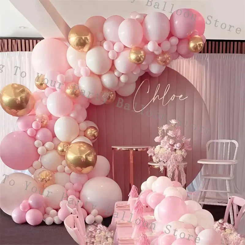 A decorative pink balloon arch kit featuring white and gold balloons in various sizes for wedding and birthday parties.