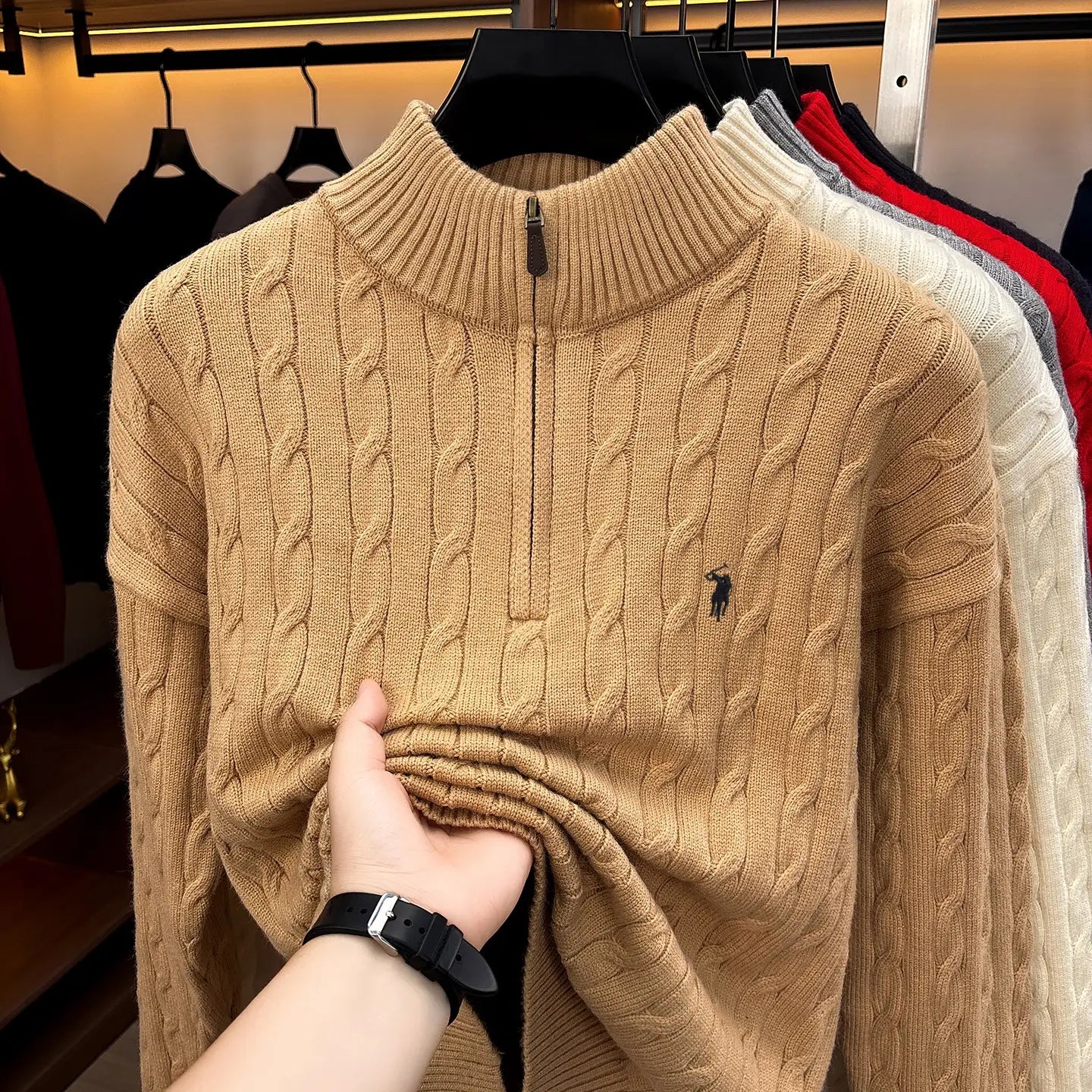 Herren-Designer-Sweater aus sandfarbenem Zopfmusterstrick mit halbem Reißverschluss, mit kleinem schwarzem besticktem Polo-Spieler-Logo auf der Brust.