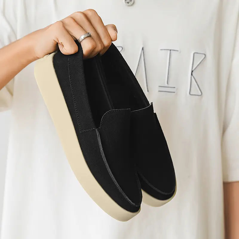 Black suede slip-on Men casual loafers with a cream-colored platform sole for walking.