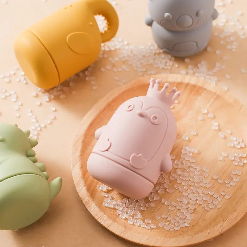 Rosa Silikon-Pinguin in Babyflaschenform mit Kronendesign, präsentiert im Produkt des Silikon-Koala-Baby-Badesprinkler-Spielzeugs.