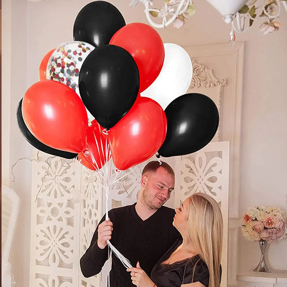 ein festliches Set aus roten, schwarzen und weißen Latexluftballons, einschließlich eines mit Konfetti gefüllten Ballons, für Partydekoration