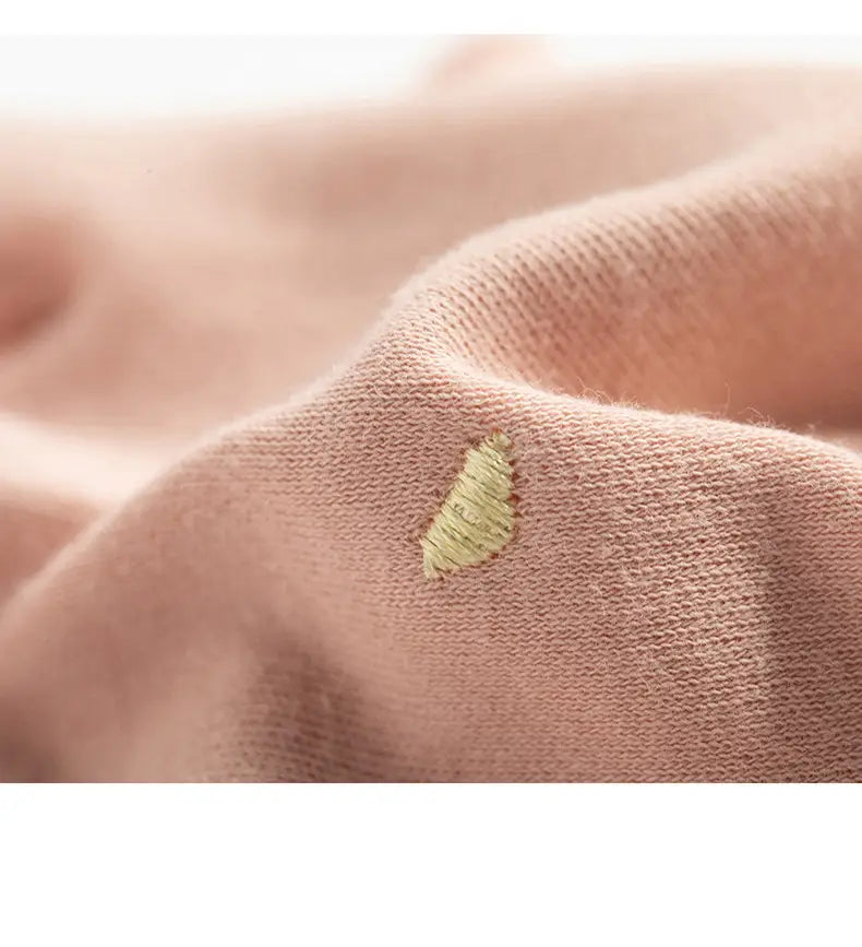 UV-Schutz-Maniküre-Fahrhandschuhe für Damen aus weichem blassrosafarbenem Strickstoff mit einem kleinen hellgrünen bestickten Applikationspatch.