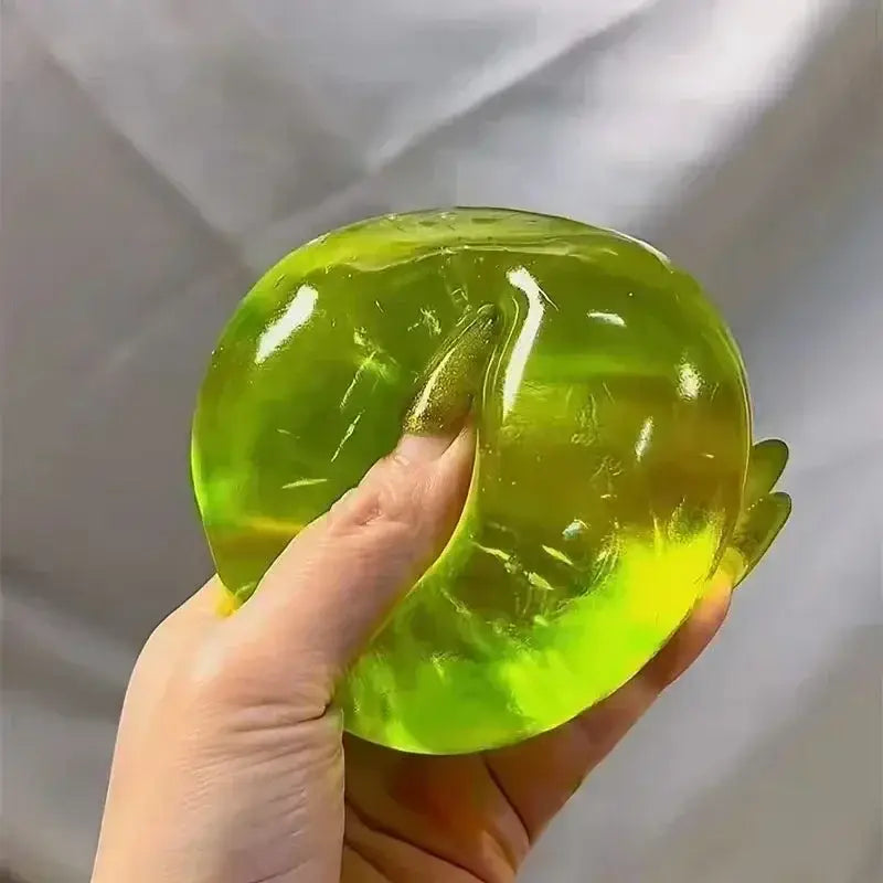 Un jouet à mâcher et à malaxer en forme de fromage gélatineux translucide vert citron, conçu pour soulager le stress, texture souple et molle, avec une surface brillante et des tourbillons internes subtils, conçus pour apaiser le stress lié au jouet.