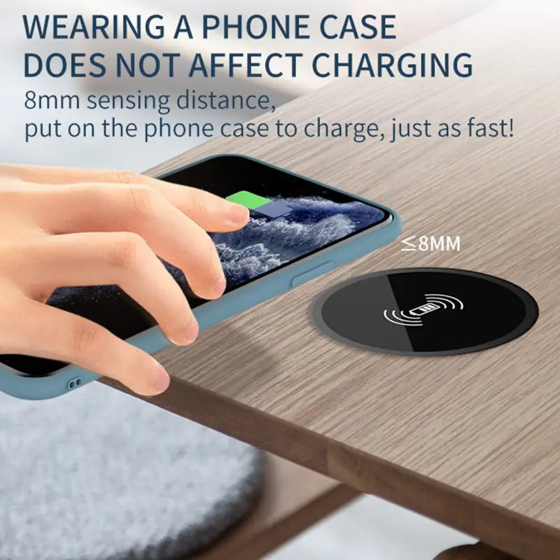 Black circular embedded desk wireless charger made of durable material featuring fast 15w charging with a white radio wave symbol and text indicating compatibility with devices up to 8mm thick.