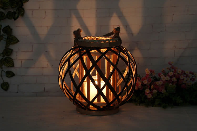 Porte-bougie en bambou tissé à la lueur chaleureuse, avec un motif en treillis et des poignées en bois rustique, pour une décoration intérieure élégante.