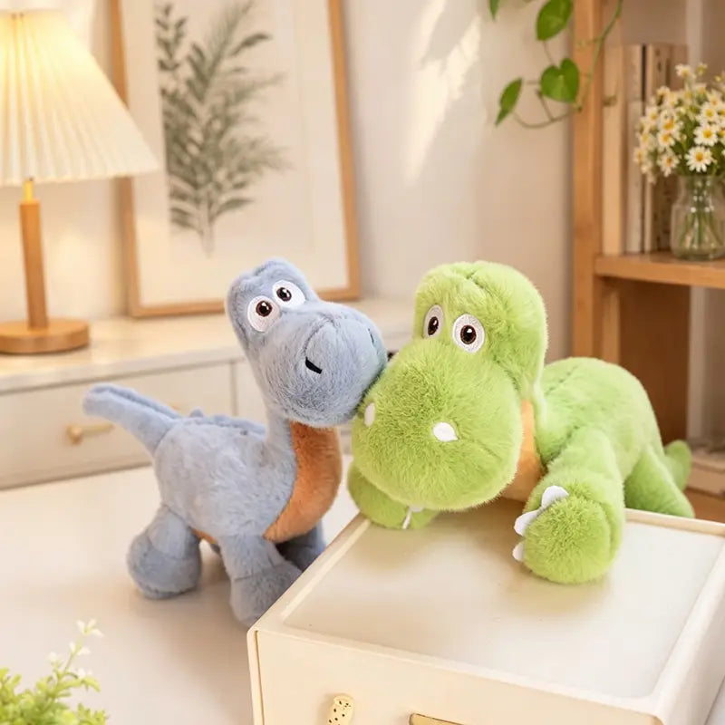 Deux jouets peluches de dinosaure colorés, peluches souples, avec des corps en tissu souple bleu clair et vert vif, un dessous du ventre orange et des yeux cousus.