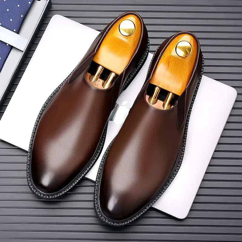 Chaussures habillées à enfiler en cuir pour hommes, marron, avec cuir poli, semelles en caoutchouc noir et semelles intérieures en bois avec des accents métalliques de couleur dorée.