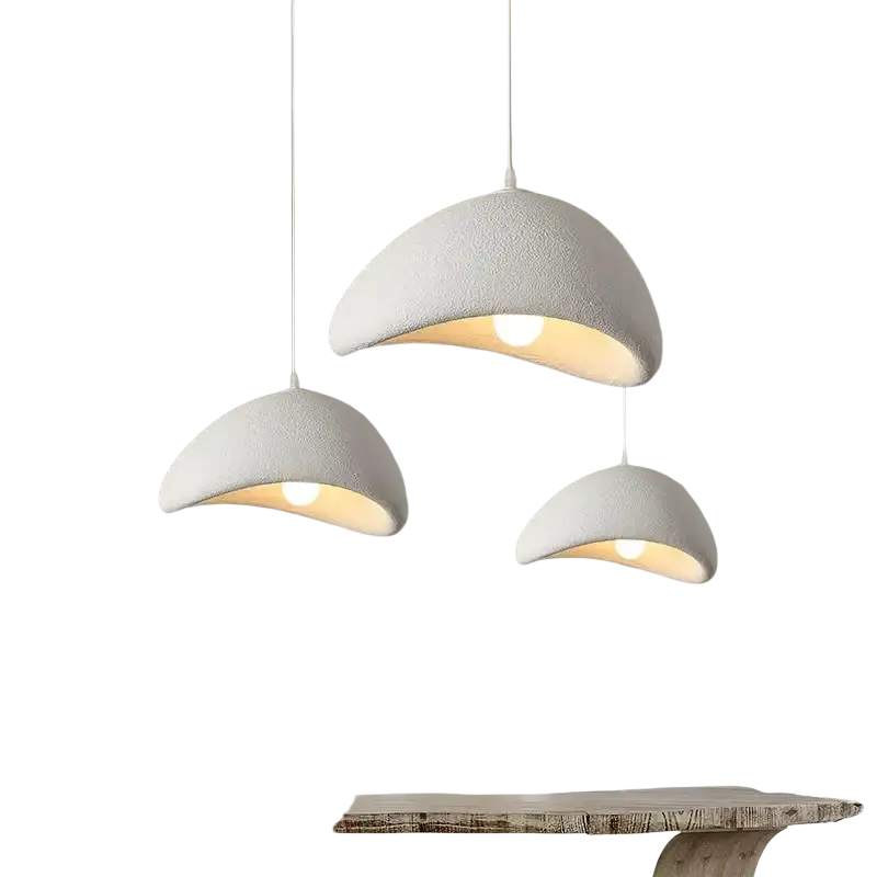 Three white textured pendant lights with a curved design hanging from the ceiling for living room and dining room use