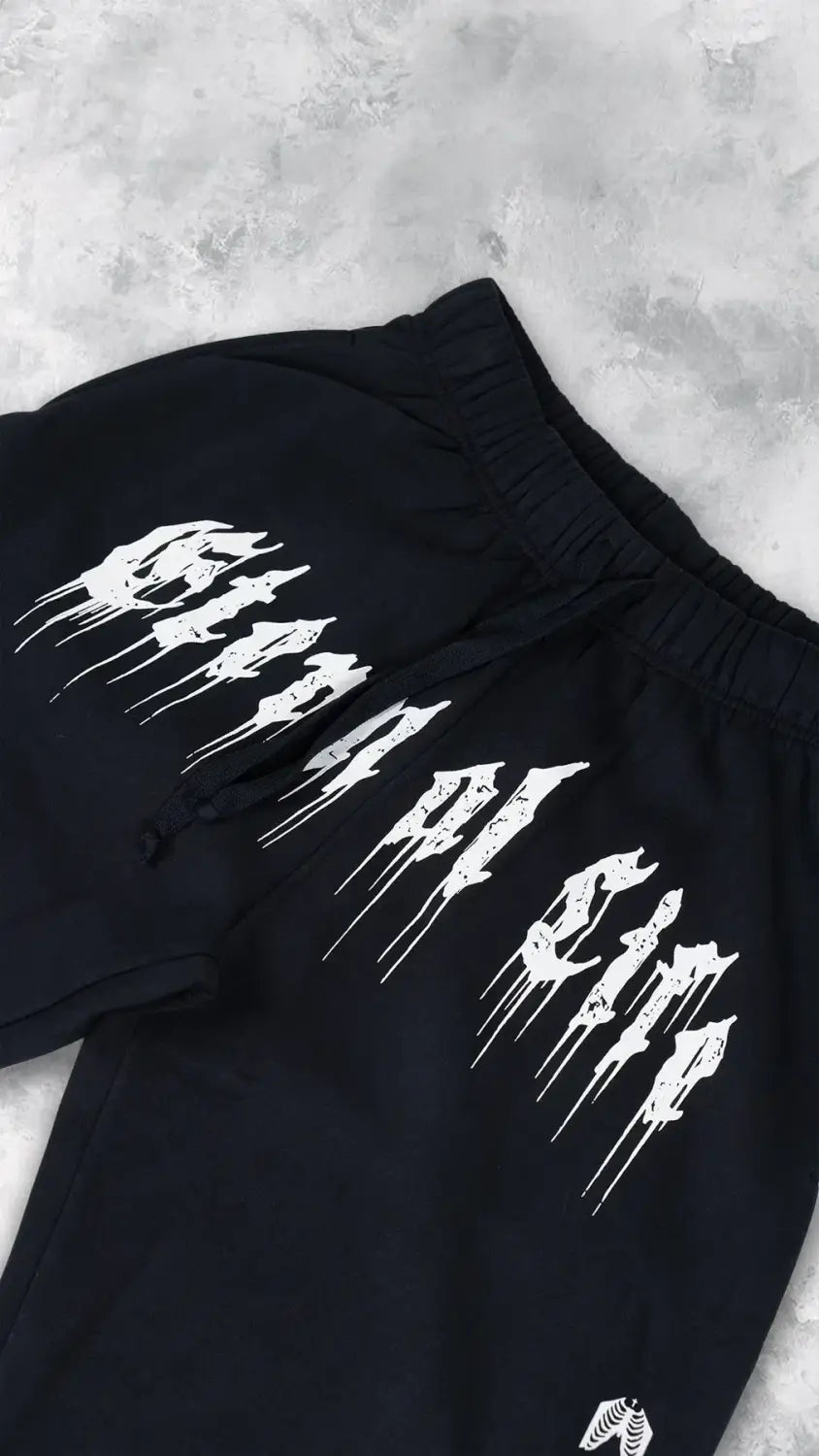 Survêtements d’entraînement graphiques pour hommes noirs, sweatpants, avec un graphisme audacieux en style graffiti blanc « born to die » sur la cuisse, pour un usage en vêtements d’entraînement.