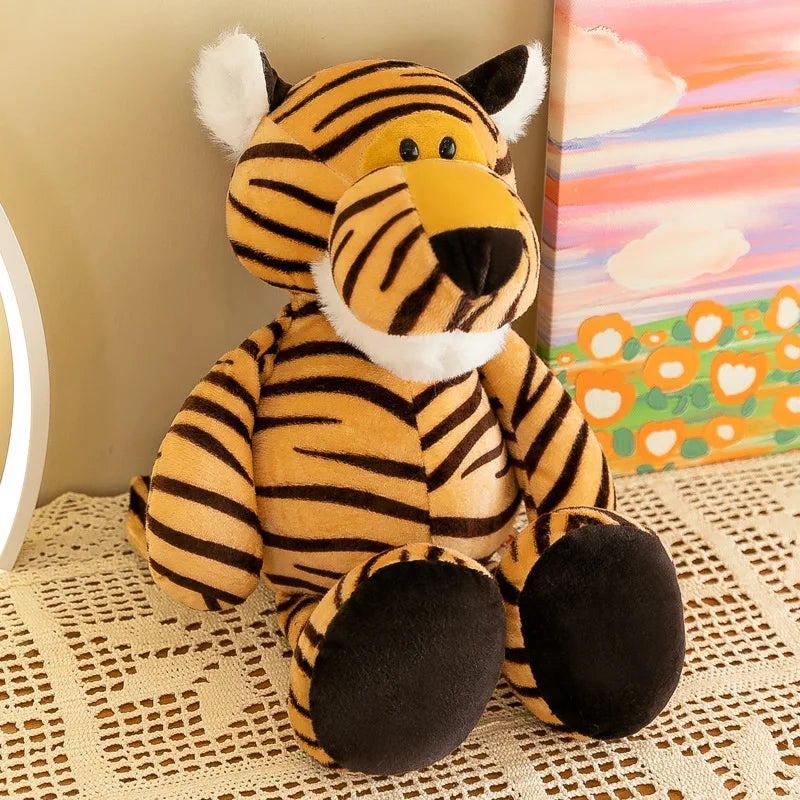 Un peluche de tigre con rayas naranjas y negras, y pelaje blanco en sus orejas, hocico y patas, sentado en posición erguida; forma parte de la colección de muñecos blandos de animales de la jungla.