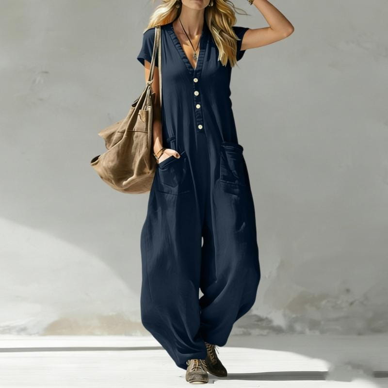 A navy blue wide leg jumpsuit for women featuring a button-front design and front pockets.