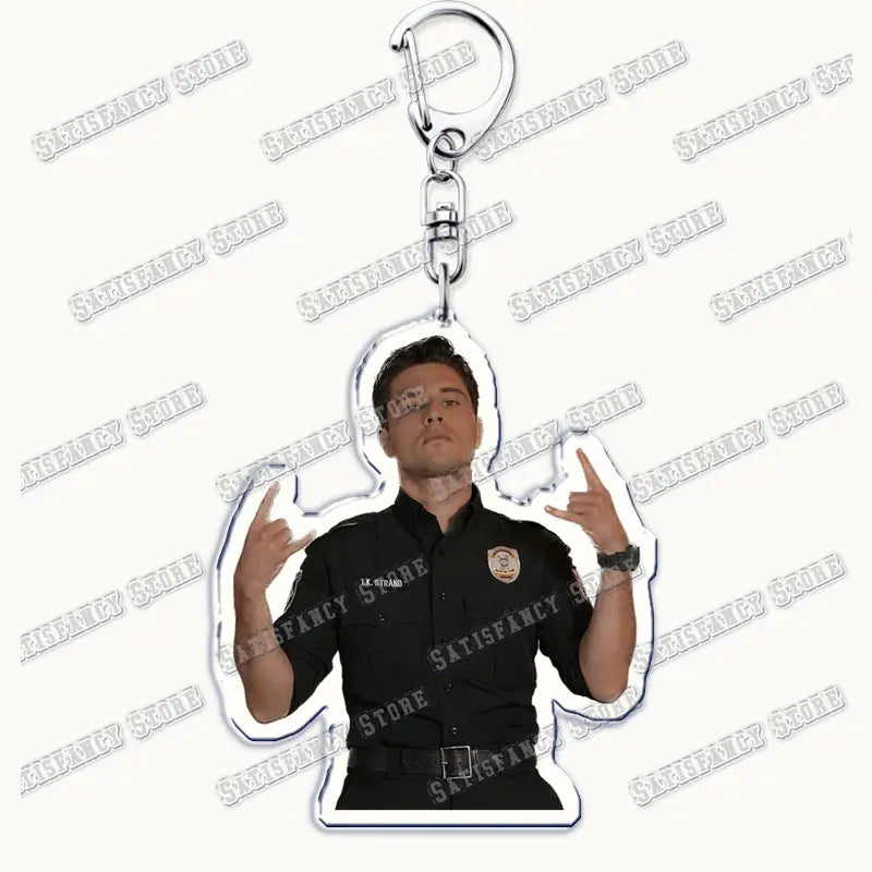 Black acrylic keychain featuring a character from 9-1-1 tv show in a police uniform making rock hand gestures, ideal as a firefighter gift.