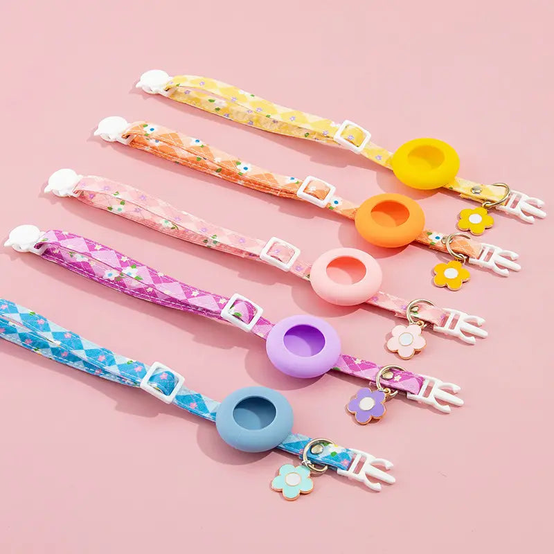 pastel-colored silicone airtag protective case designed as a cat collar with floral-patterned fabric straps and matching flower charms for outdoor park dog and park dog cat use