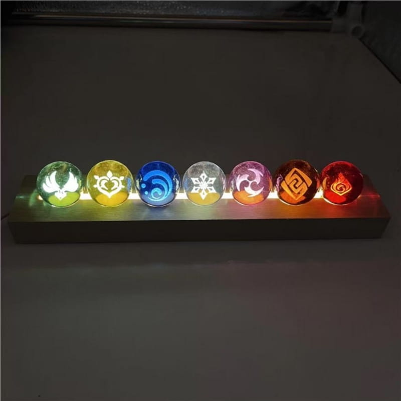 Une base rectangulaire à LED épurée, supportant six sphères de verre translucides et lumineuses gravées de symboles élémentaires de Genshin Impact, comme produits finis de la collection de boule de cristal.