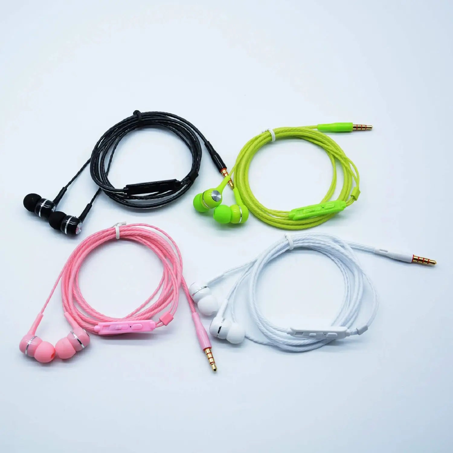 A set of four 3.5mm wired in-ear headphones with mic featuring colorful black, neon green, pink, and white designs with coiled cables and inline controls.