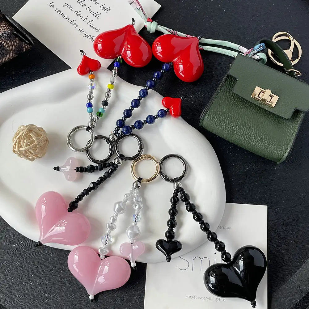 Ensemble de porte-clés en forme de cœur brillant, de couleur rouge, rose et noire, avec des chaînes à perles et des anneaux en métal, destiné à servir de pendentifs pour sac.