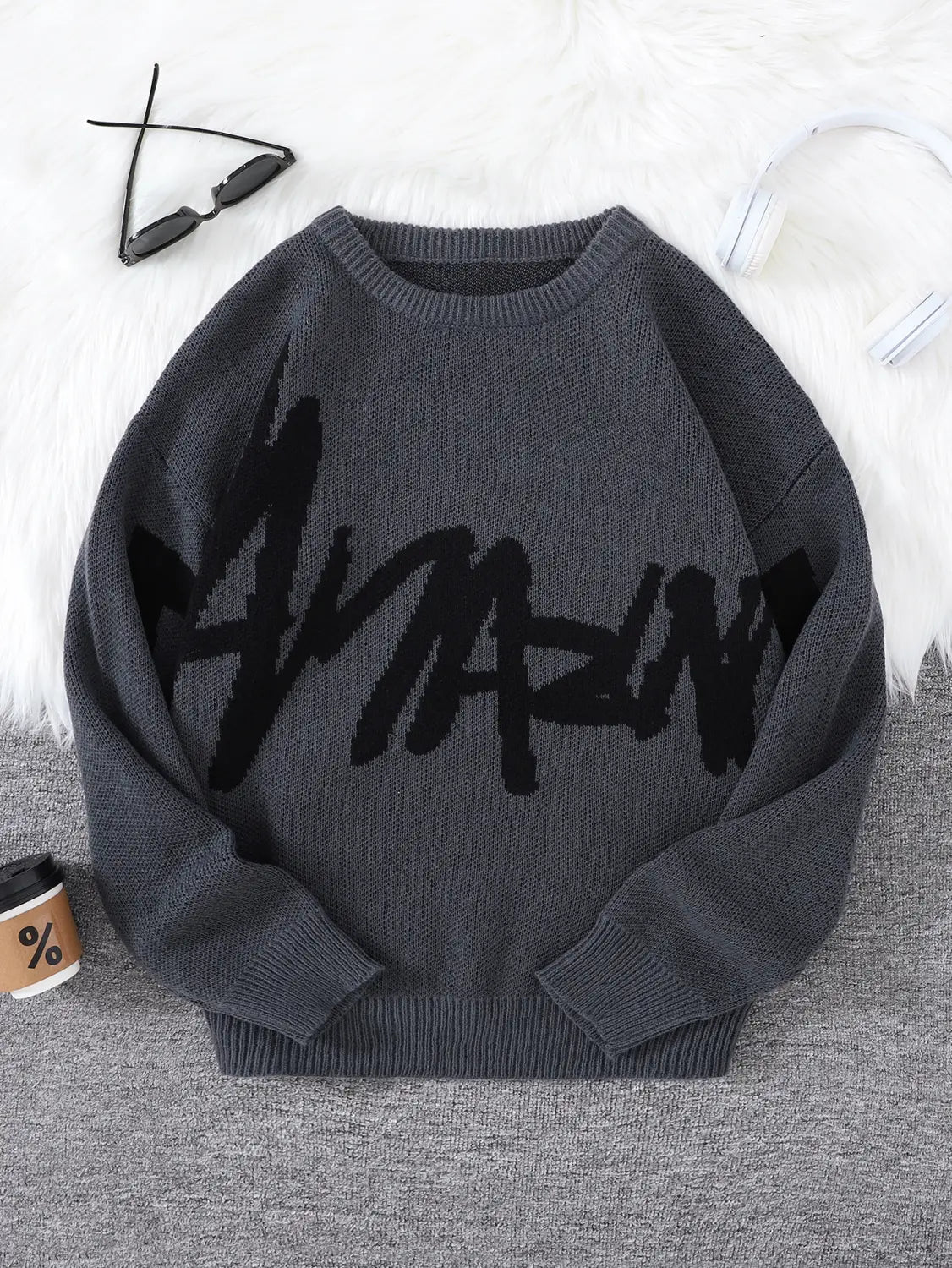 Men black amazing graphic knit sweater featuring a dark gray knit fabric with bold black amazing lettering across the chest.