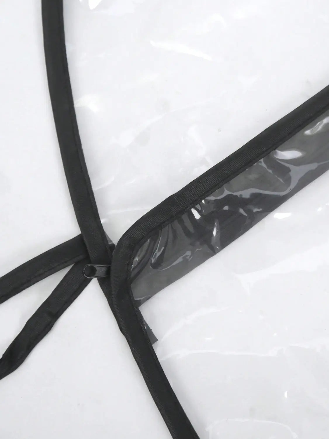 Universelle transparente Regenschutzabdeckung für Kinderwagen aus klarem Kunststoff mit schwarzem verstärktem Besatz und Reißverschluss.