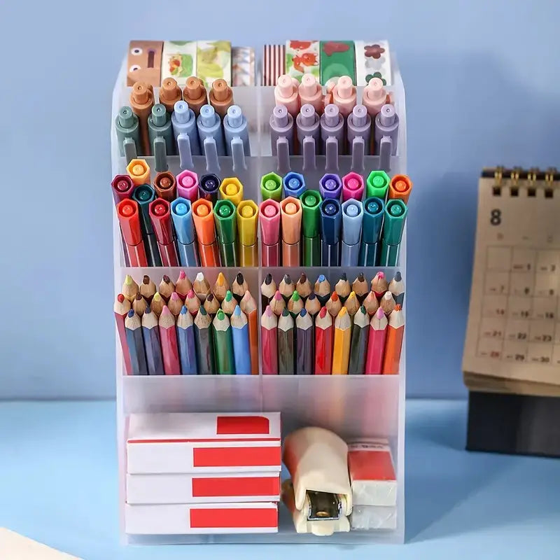 Clear plastic pen holder desktop stationery organizer with multiple transparent compartments filled with colorful pens pencils washi tape rolls and office supplies.