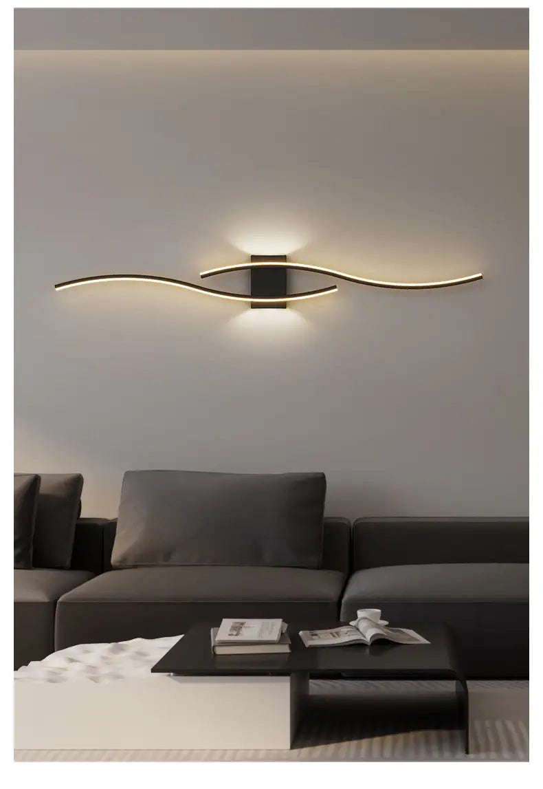Aplique de pared LED minimalista con luz de tira moderna, con un acabado metálico negro y dorado elegante, que presenta un diseño curvo y emite una luz ambiental cálida.