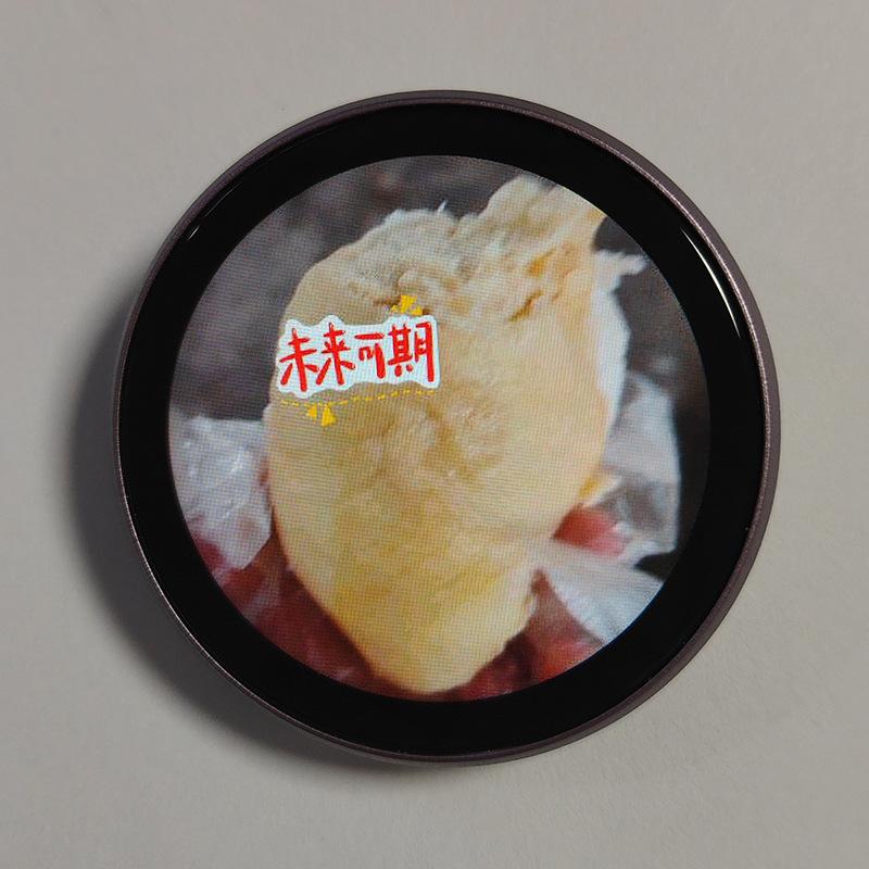 Circular black-framed mini gadget smart desktop companion displaying a close-up image of a yellow durian fruit with an included data cable.