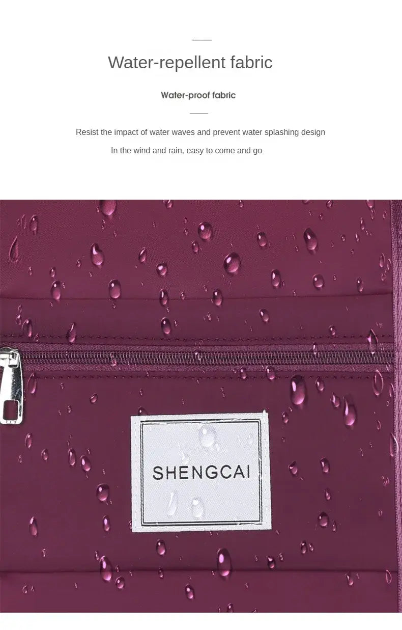 Un sac duffel roulant bordeaux en tissu déperlant pour l’épaule (crossbody) à grande capacité, avec fermeture à glissière et étiquette shengcai, conçu pour les voyages.