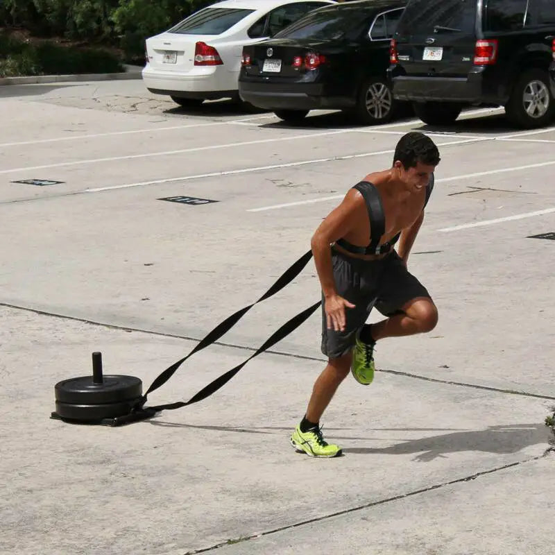 Black weighted sled with adjustable straps for agility training resistance harness sled pull strap used in outdoor fitness workouts