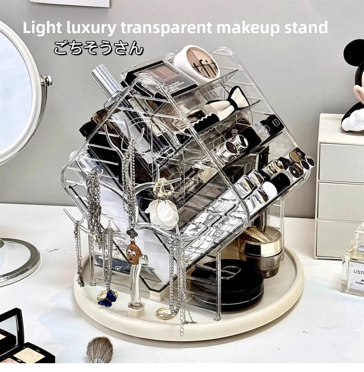 Organisateur de maquillage rotatif en acrylique transparent en forme de maison, avec une base circulaire blanche, conçu pour ranger et mettre en valeur les cosmétiques.