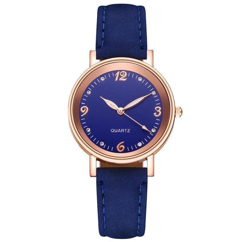 A women quartz watch with a navy blue leather strap, rose gold-tone case, matching hour markers, and small crystal accents on the dial.