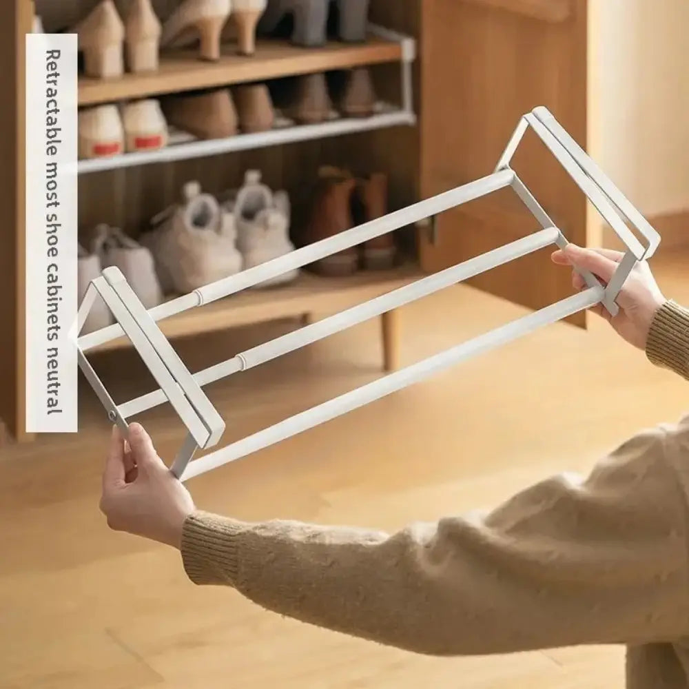 White telescopic shoe rack with a minimalist metal design for efficient shoe storage and organization.