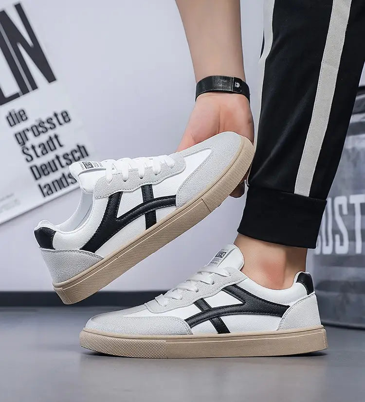 Sneakers décontractées pour hommes, chaussures de marche légères, avec un dessus en daim gris texturé, des rayures noires marquées sur le côté et une semelle extérieure en caoutchouc beige.