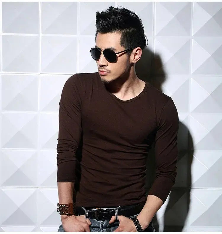 Une chemise ajustée brun foncé élégante à manches longues, col rond classique, conçue comme un t-shirt homme à manches longues et encolure en V, coupe slim.