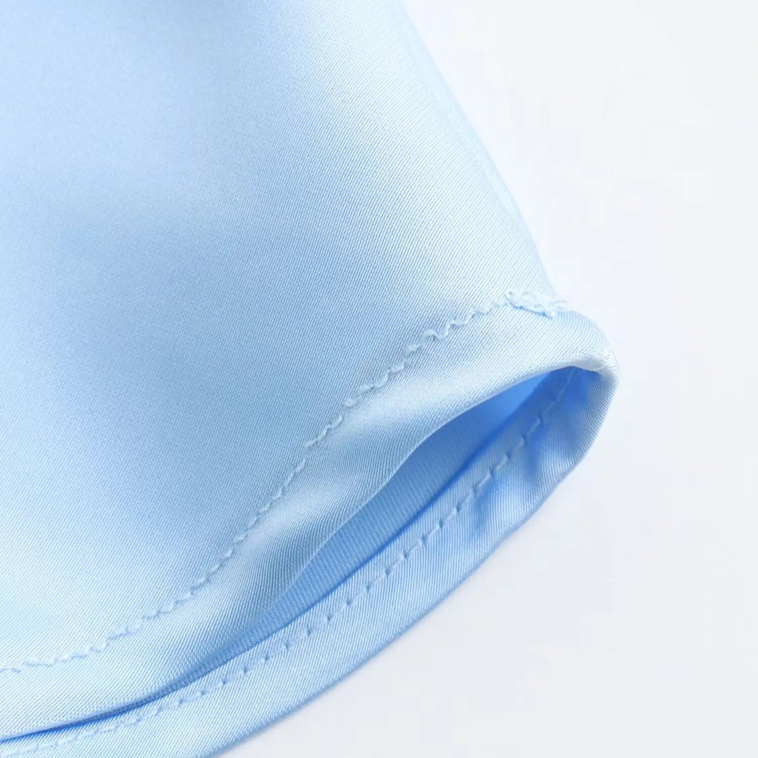 Jupe midi en satin bleu clair, à taille haute, avec des coutures fines et régulières le long du bord replié du tissu