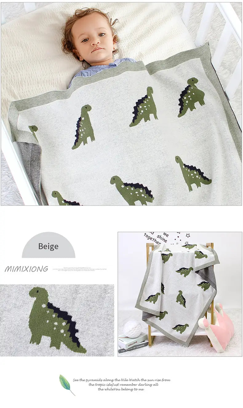 Beige gestrickte Baumwoll-Dinosaurier-gestrickte Babyddecke mit grünen Dinosauriermustern und grauem Rand, geeignet als Wickeldecke für das Gitterbett.