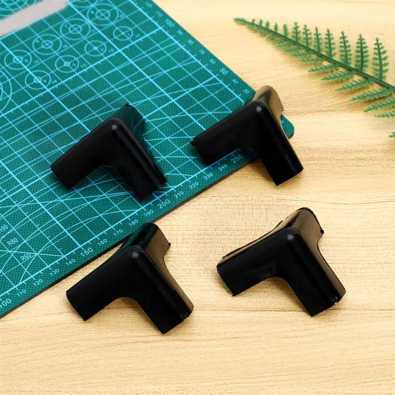 schwarze Kunststoff-Eckschutzwinkel mit glatter glänzender Oberfläche als Eckschutz für Tischkanten, im Vierer-Set