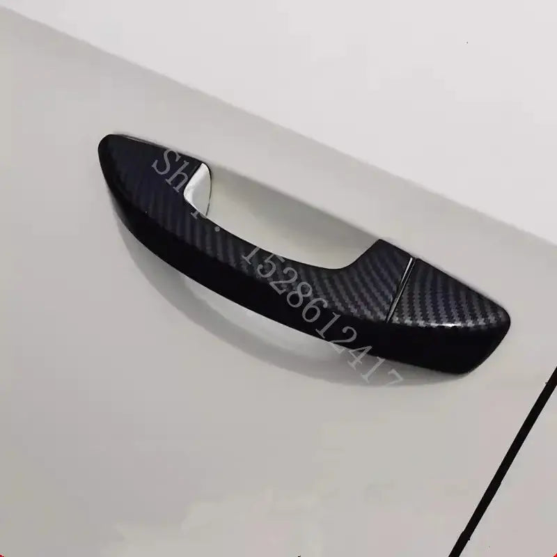 Black carbon fiber textured door handle cover for VW Passat shown from the back side.
