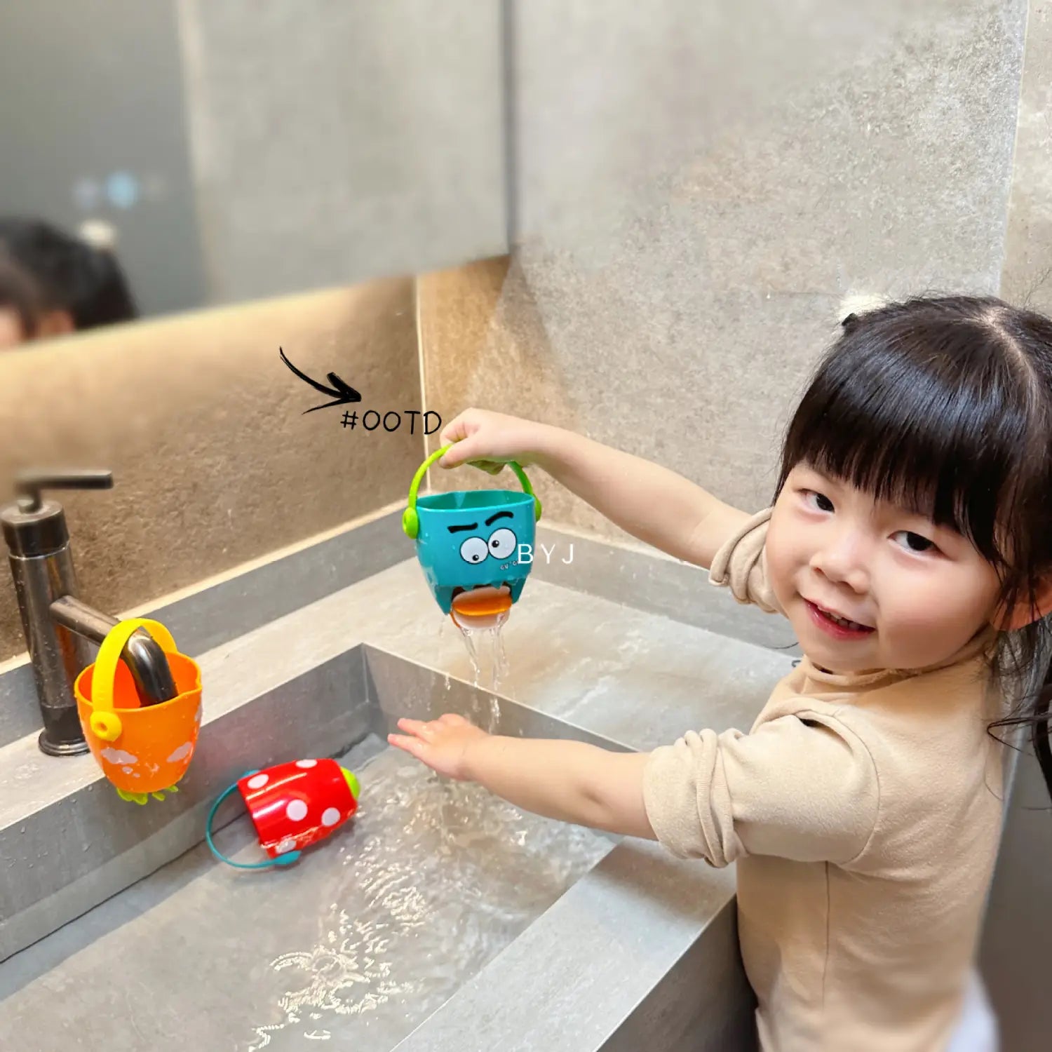 Blauer Plastik-Wassersprenger für Kinder (Gießkanne) mit grünem Griff und Cartoon-Gesichtsdesign aus dem Spielset für Baby-Badewannen-Eimer mit Wassersprühfunktion für das Baden mit Kindern.