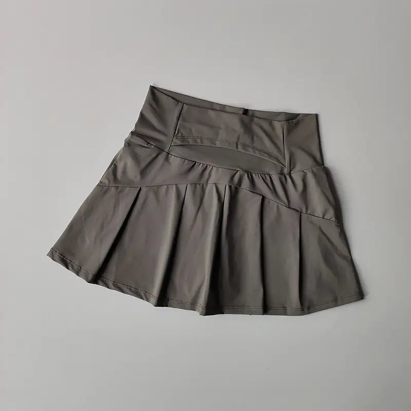 Ein eleganter dunkelgrauer High-Waist- plissierter Tennisrock mit strukturiertem Bund und dezenten Ziernähte-Details, ausgelegt für schnelltrocknende sportliche Nutzung.