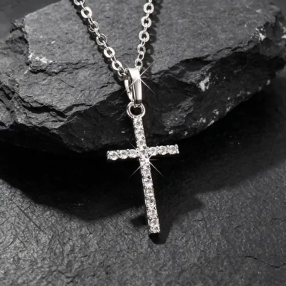 Collier en argent avec pendentif en forme de croix, orné de strass étincelants le long de ses branches et rattaché à une chaîne en argent délicate, dans un collier en argent avec pendentif en forme de croix en cristal.