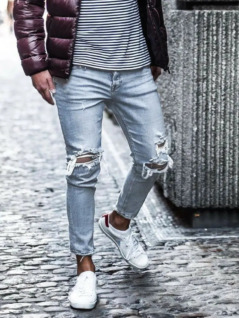 Herren-Distressed-Slim-Fit-Light-Wash-Denim-Jeans mit zerrissenen Knien und ausgefransten Kanten.