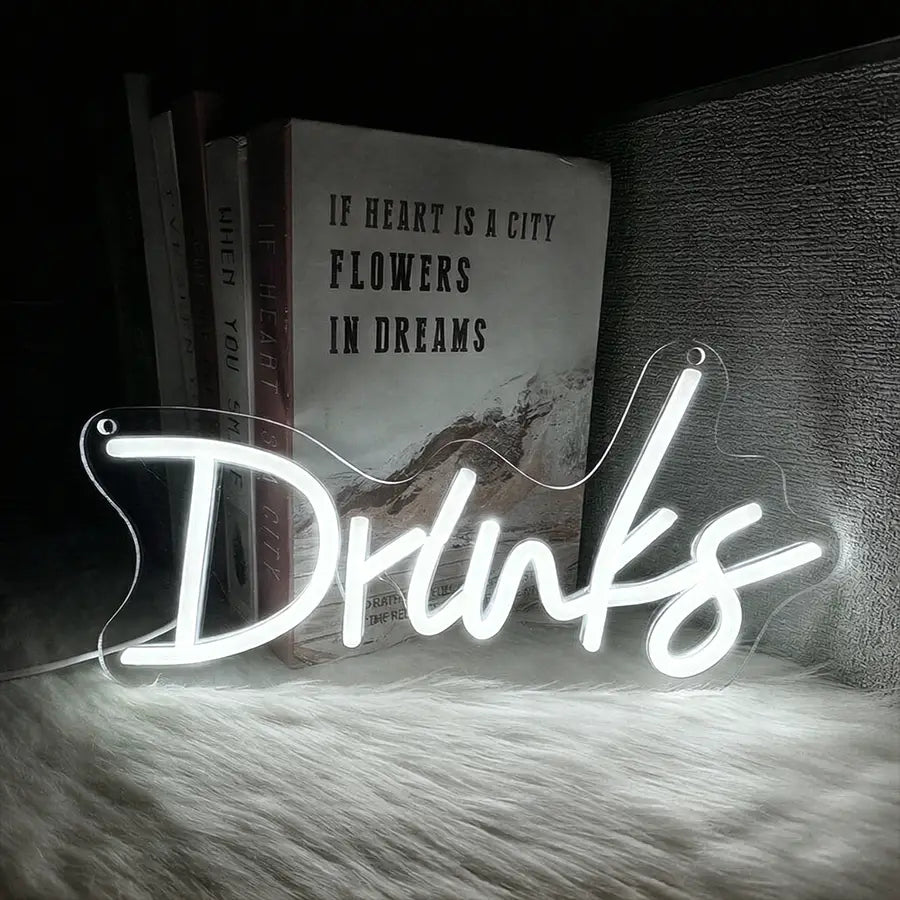 une enseigne au néon blanc lumineux avec le mot « drinks » dans une écriture cursive, conçue comme décoration murale à LED