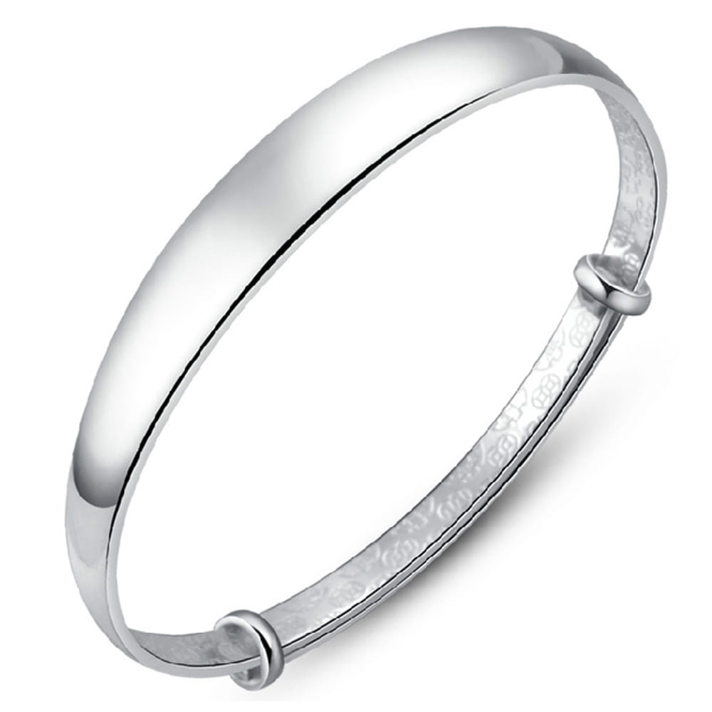 Sterling silver round bangle bracelet for women with a silver-toned smooth polished outer surface and an intricately engraved inner band.